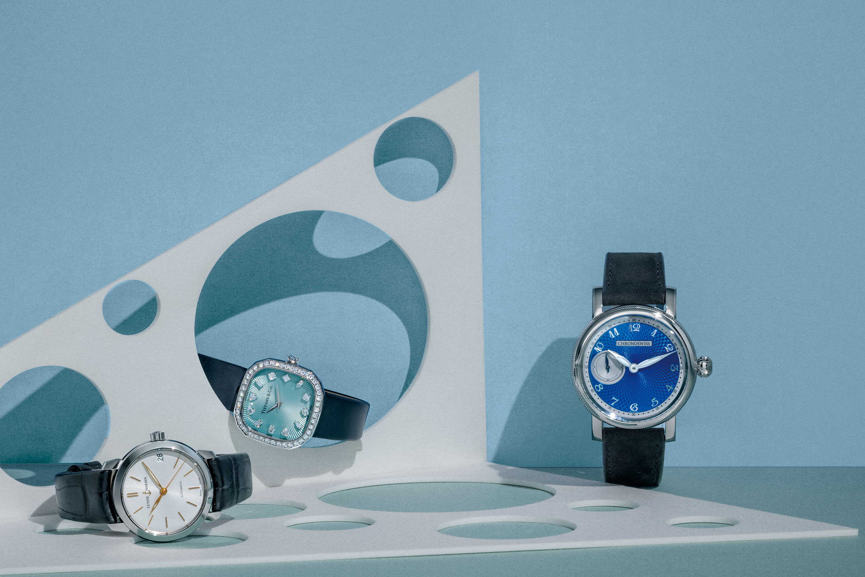 （左） Ulysse Nardin 鎏金系列自動腕錶，搭載 UN-810 自動上鍊機芯，不鏽鋼錶殼，時間顯示，錶徑 31mm ，防水深度 30 米。 （中） Tiffany & Co. Eternity 枕形腕錶，搭載高度精確瑞士石英機芯，18K 白金錶殼鑲鑽石，時間顯示，尺寸 28mm ，防水深度30 米。 （右） Chronoswiss Small Second 腕錶，搭載瑞寶自製自動上鍊機芯 C. 6000，不鏽鋼錶殼，時間顯示，錶徑 40mm。